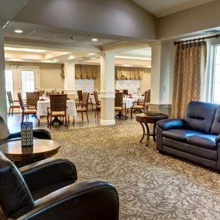 A comfortable lounge area featuring leather chairs and a sofa, adjacent to a dining space.