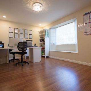 A spacious and organized home office with hardwood floors and ample natural light.