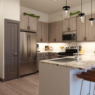 A modern kitchen with an island, featuring stainless steel appliances and stylish pendant lighting.