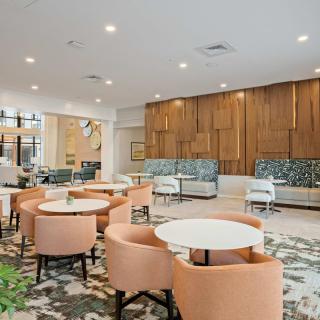 A modern and stylish lounge area featuring a variety of seating options with soft lighting and contemporary wood paneling.