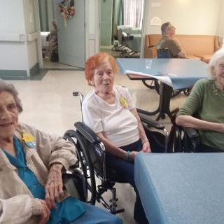 A group of elderly individuals sitting together in a nursing home.