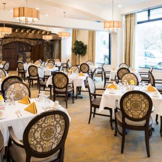 An elegant restaurant dining room with tables set for service.