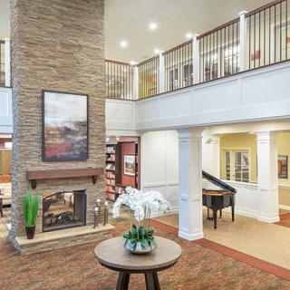 Elegant lobby interior with a fireplace and grand piano.