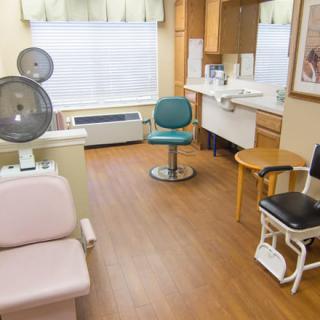 A cozy salon with various seating and a hair dryer station.