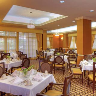 A beautifully set restaurant dining room with elegant decor and neatly arranged tables.