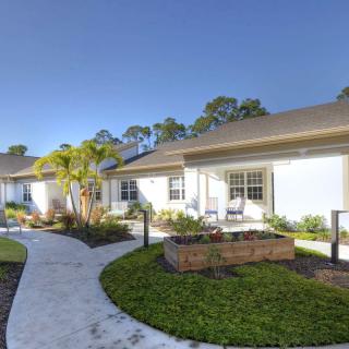 A modern residential complex with well-maintained gardens and a winding pathway.