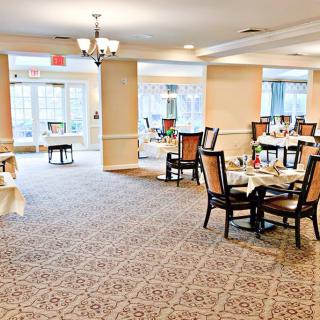 A spacious dining area with elegantly set tables and ample natural light.