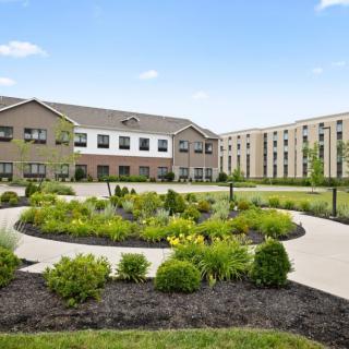 A scenic view of a landscaped garden in front of a modern building complex.