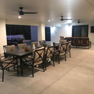 Spacious outdoor patio with dining area and ceiling fans.