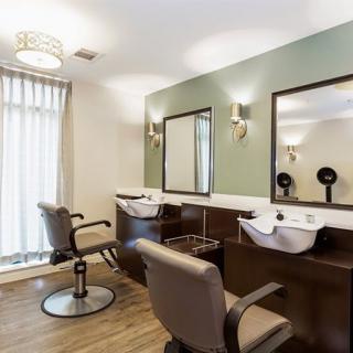 A modern hair salon interior with styling chairs and wash basins.