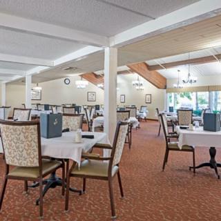 A spacious dining room with neatly arranged tables and chairs, offering a comfortable setting for meals.