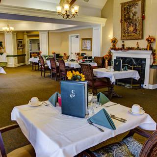 A well-appointed dining area with neatly arranged tables, featuring a menu and elegant dcor.