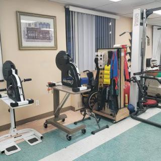 A physical therapy room equipped with various exercise machines and rehabilitation tools.