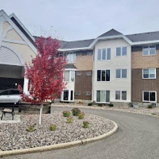 A modern apartment building with autumn foliage and well-maintained landscaping.
