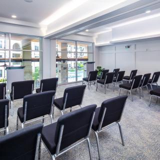 An empty conference room with rows of chairs arranged for a meeting.