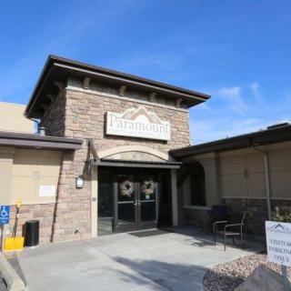 The exterior entrance of a restaurant with a stone facade on a sunny day.
