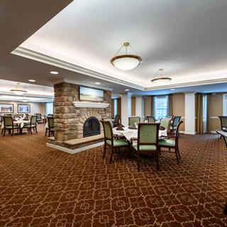 A spacious dining room with elegant furnishings and a cozy fireplace.