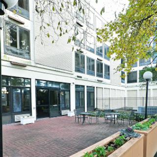 A tranquil courtyard area featuring modern architecture with seating arrangements surrounded by greenery.