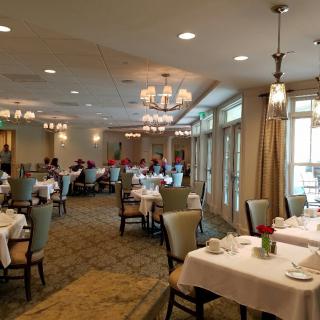 An elegant dining room with neatly arranged tables and chairs, featuring soft lighting and tasteful decor.