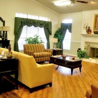 A cozy living room featuring comfortable seating, elegant curtains, and a warm fireplace.