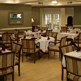 An empty restaurant dining room with neatly arranged tables and chairs.