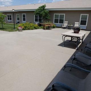 A spacious patio area with outdoor seating and landscaping in front of a building.