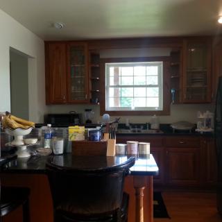 A cozy kitchen with wooden cabinets and a variety of kitchenware on the countertop.