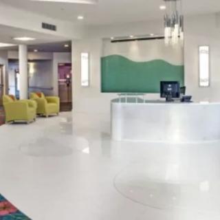 A bright and modern hotel lobby with a reception desk and comfortable seating.