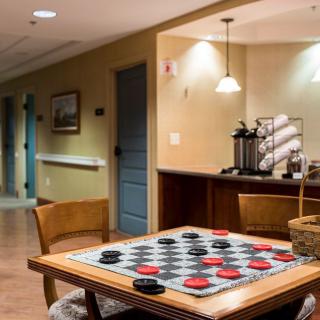 A cozy game room featuring a checkers board and a coffee station.