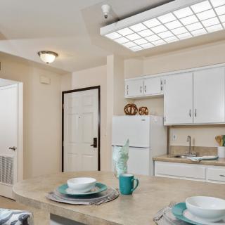 A modern kitchen interior with white cabinets and a cozy dining area.