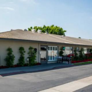 A single-story residential building with a driveway and landscaped front yard.