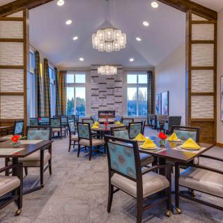 A modern dining room with elegant chandeliers, well-arranged tables, and a sophisticated design.