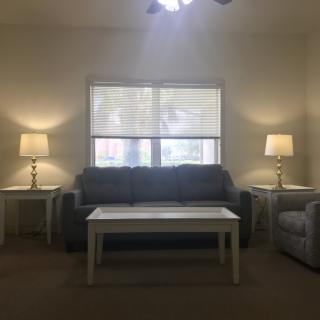 A cozy living room with a sofa, coffee table, and matching lamps on side tables.
