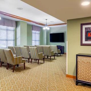 A neatly arranged conference room with rows of seats facing a television screen.
