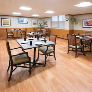 A spacious and inviting dining area featuring wooden tables, comfortable chairs, and tasteful decor.