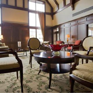 A luxurious living room with elegant furniture and classic wood paneling.