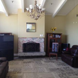 A cozy living room featuring a fireplace, chandelier, and comfortable seating.
