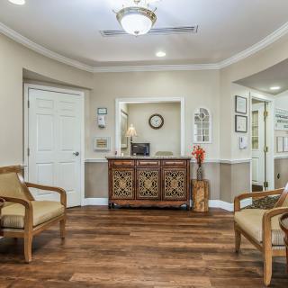 A cozy waiting room with wooden flooring and comfortable seating.