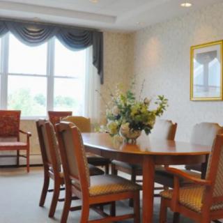 A cozy dining room with wooden furniture and a decorative flower arrangement on the table.