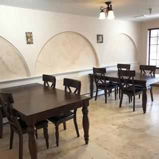 A cozy dining area with wooden tables and chairs, featuring a simple, elegant interior design.