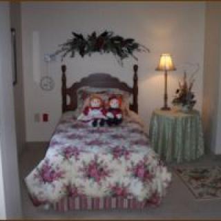Cozy bedroom with a floral-themed bed and decorative dolls.