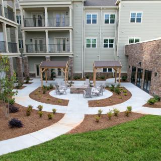 A well-landscaped courtyard with outdoor seating at an apartment complex.