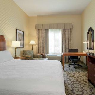 A cozy hotel room featuring a comfortable bed, desk area, and inviting decor.