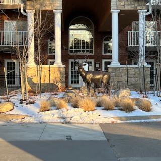 A sculpted horse stands in a snowy landscape, welcoming visitors to the building.