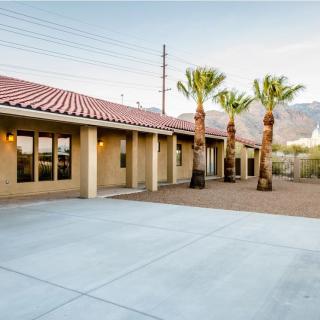 A spacious backyard with palm trees and a mountain view, captured at sunset.