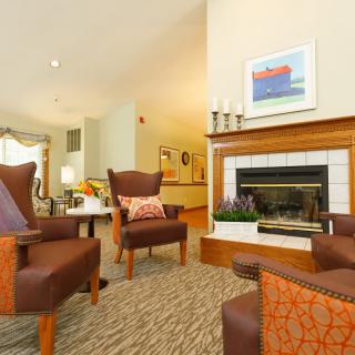 A cozy living room with comfortable chairs and a warm fireplace.