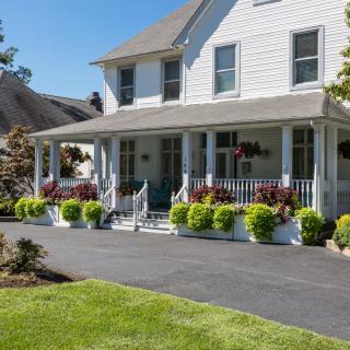 A charming house with a spacious front porch and well-maintained garden.