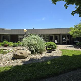 A scenic view of a modern building surrounded by well-maintained landscaping and greenery.