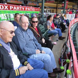 A group of people sitting in a stadium, enjoying a baseball game.