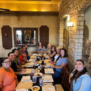 A joyful gathering of friends enjoying a meal together at a restaurant.